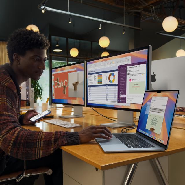 Person using MacBook Air 15" on a desk with two Studio Displays also in use.