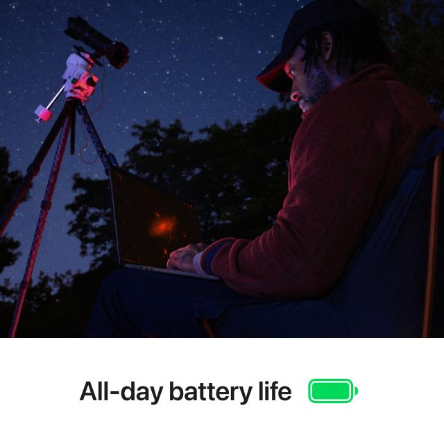 Behind view of person using MacBook Pro 16 inch outside while stargazing. Below text reads "All-day battery life"