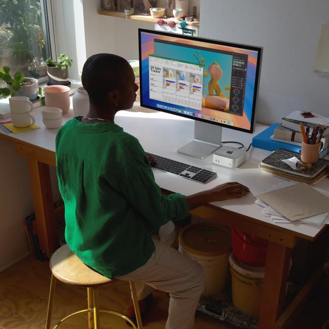 Person using Mac Mini paired with the Studio Display