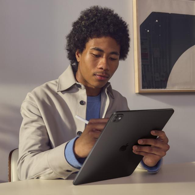 Person using iPad Pro and Apple Pencil at a table